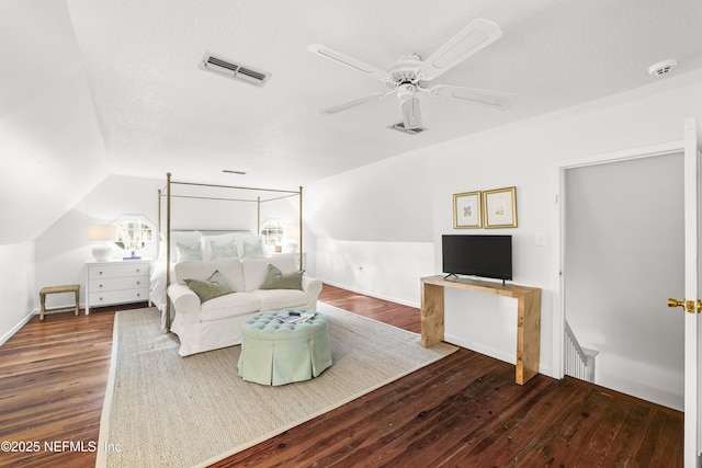 bedroom featuring dark wood-type flooring, ceiling fan, vaulted ceiling, and a textured ceiling