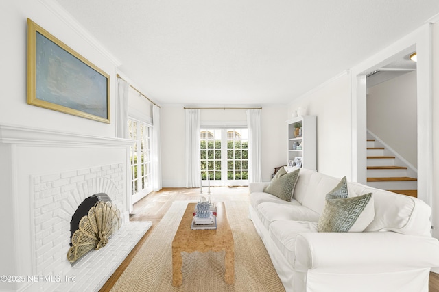 living room featuring ornamental molding and a brick fireplace