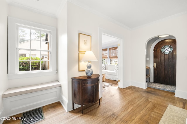 foyer featuring crown molding and light wood-type flooring