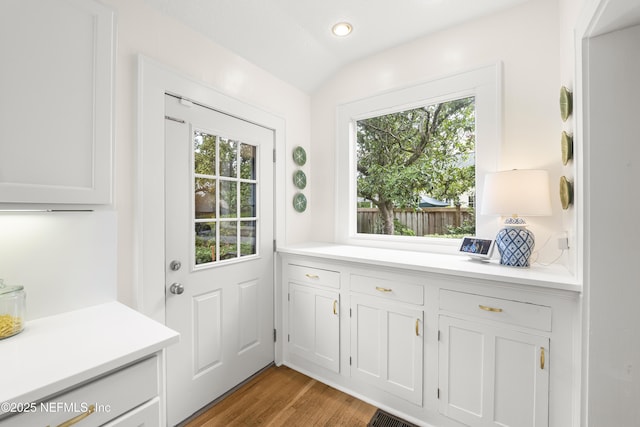 doorway to outside featuring lofted ceiling and wood-type flooring