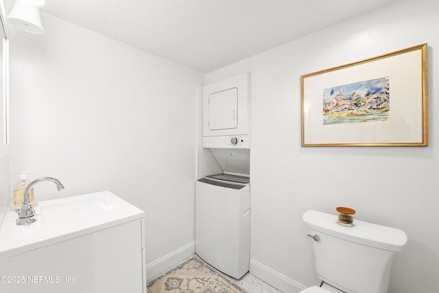 bathroom featuring toilet and stacked washing maching and dryer