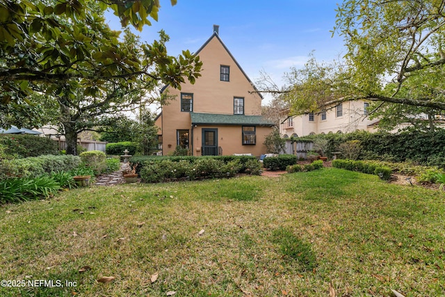 rear view of house featuring a lawn