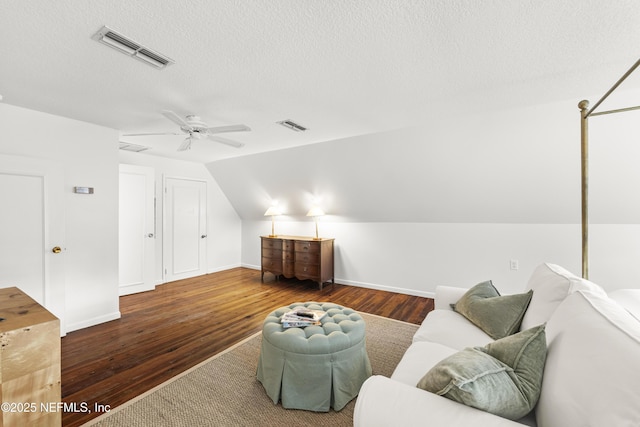 sitting room with lofted ceiling, ceiling fan, dark wood-type flooring, and a textured ceiling