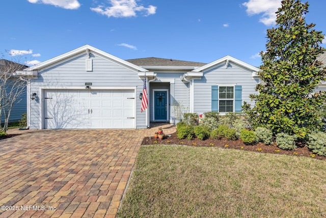 single story home with a garage, a front yard, and decorative driveway