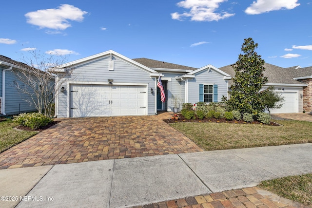 ranch-style house with a garage and decorative driveway