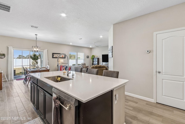 kitchen featuring light countertops, visible vents, light wood finished floors, and stainless steel dishwasher