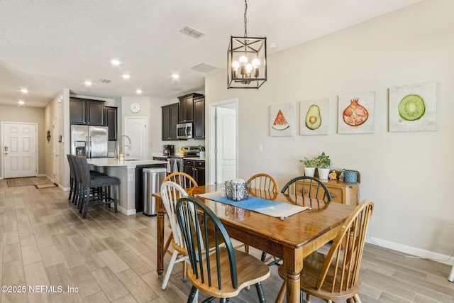 dining room featuring wood tiled floor, visible vents, baseboards, and recessed lighting