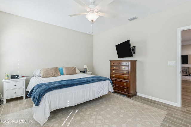 bedroom with wood tiled floor, visible vents, ceiling fan, and baseboards