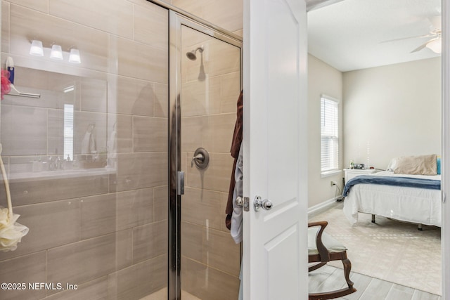 ensuite bathroom featuring ceiling fan, wood finished floors, connected bathroom, and a shower stall