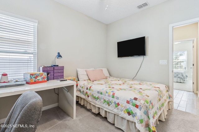 bedroom featuring carpet floors, visible vents, and built in desk