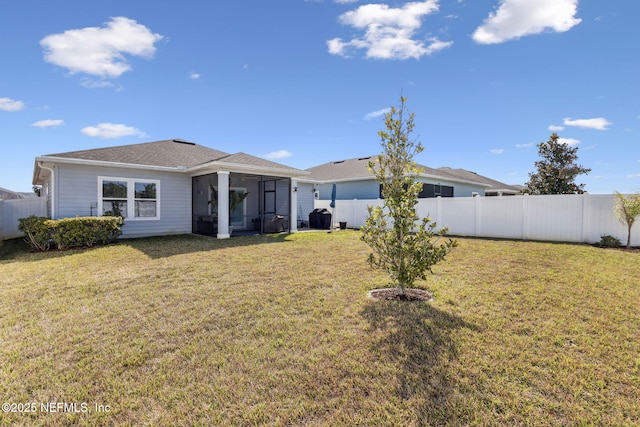 back of house with a lawn, a fenced backyard, and a sunroom