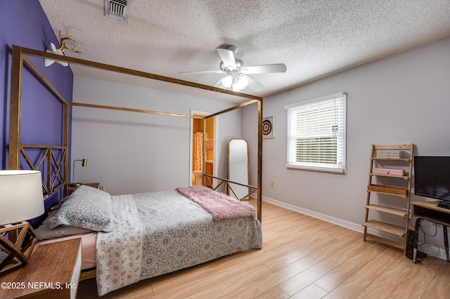 bedroom featuring ceiling fan, a textured ceiling, and light wood-type flooring