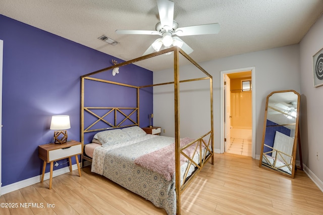 bedroom with ceiling fan, light hardwood / wood-style floors, and a textured ceiling