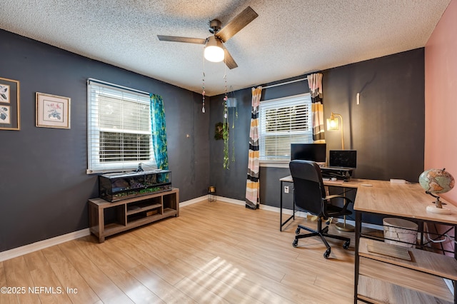 home office featuring ceiling fan, a healthy amount of sunlight, a textured ceiling, and light hardwood / wood-style floors