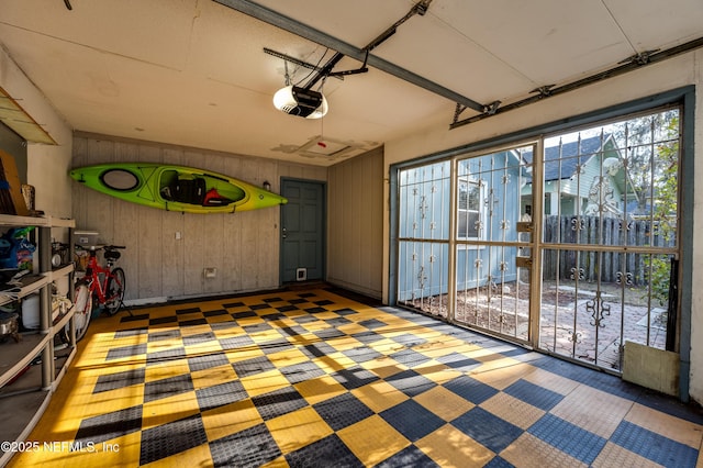 garage with a garage door opener and wooden walls