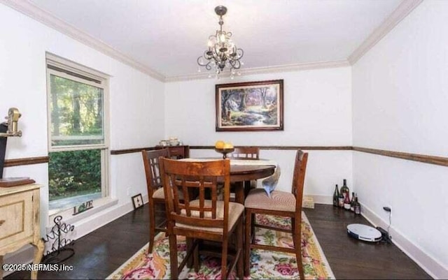 dining space with ornamental molding, an inviting chandelier, and dark hardwood / wood-style flooring