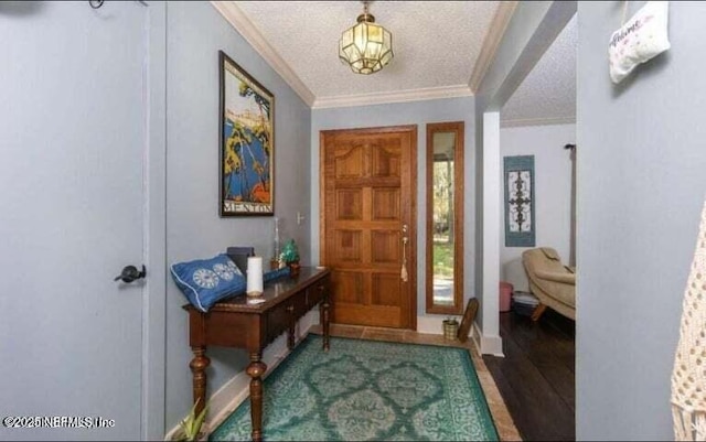 entrance foyer featuring ornamental molding, wood-type flooring, and a textured ceiling