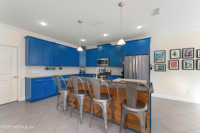 kitchen featuring stainless steel appliances, a breakfast bar, an island with sink, and blue cabinets