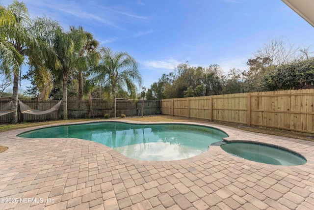 view of pool with an in ground hot tub and a patio area