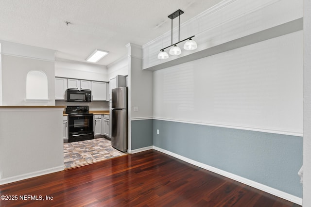 kitchen with black appliances, hanging light fixtures, ornamental molding, dark hardwood / wood-style flooring, and white cabinets