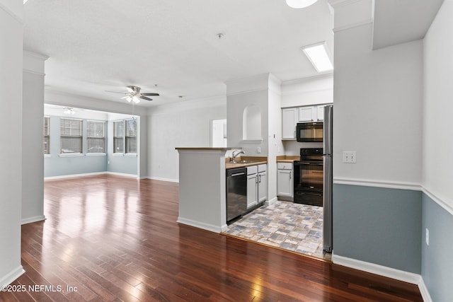 kitchen featuring butcher block counters, sink, black appliances, hardwood / wood-style flooring, and white cabinets