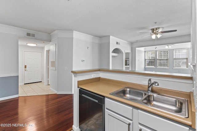 kitchen featuring dishwasher, sink, a textured ceiling, and light wood-type flooring