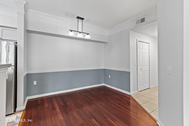 unfurnished room with ornamental molding and light wood-type flooring