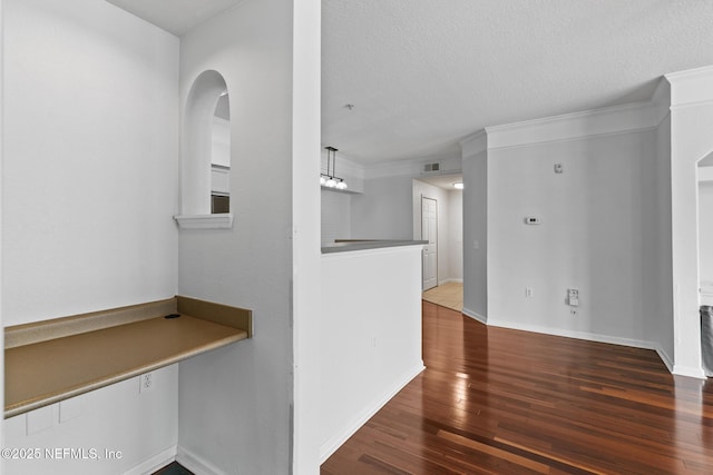 hallway featuring crown molding, dark hardwood / wood-style floors, and a textured ceiling