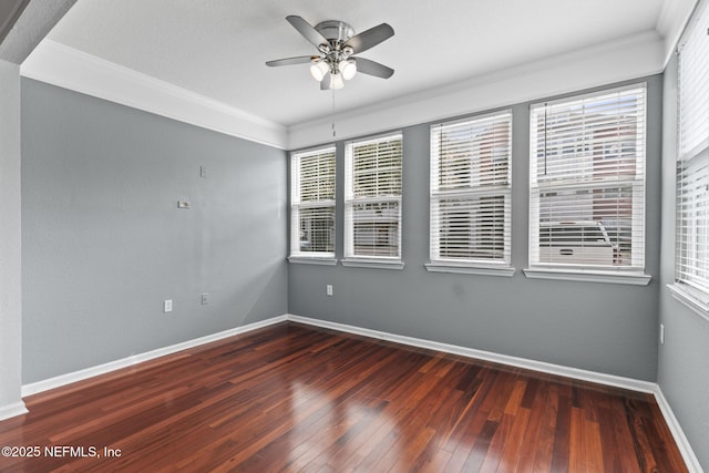 spare room with crown molding, dark wood-type flooring, and ceiling fan