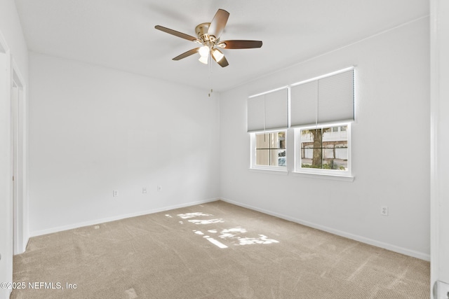 spare room featuring light colored carpet and ceiling fan