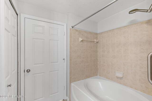 bathroom with tiled shower / bath combo