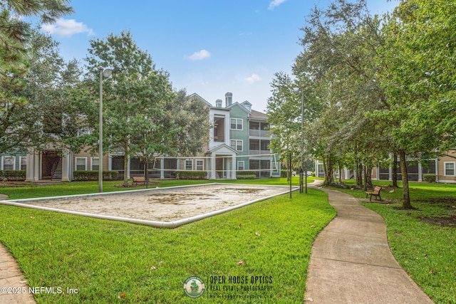 view of community featuring volleyball court and a lawn