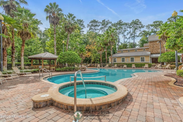 view of swimming pool with a gazebo, a patio area, and a community hot tub