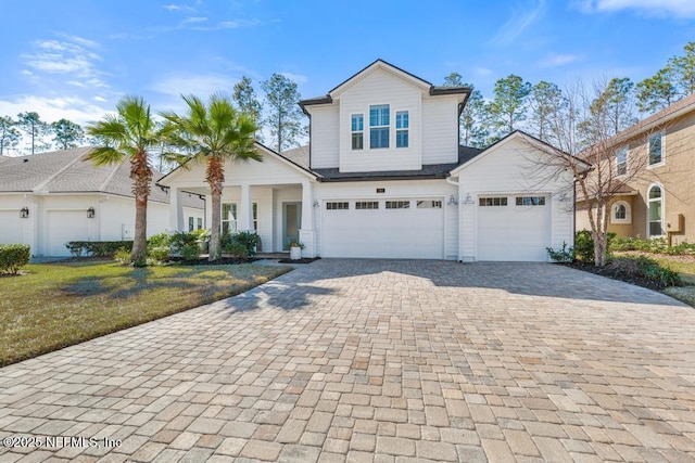 front facade with a garage and a front lawn