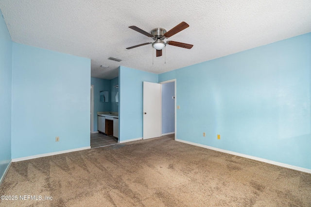 unfurnished bedroom featuring ceiling fan, connected bathroom, carpet, and a textured ceiling