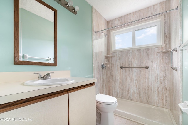 bathroom featuring tiled shower, vanity, a textured ceiling, tile patterned floors, and toilet