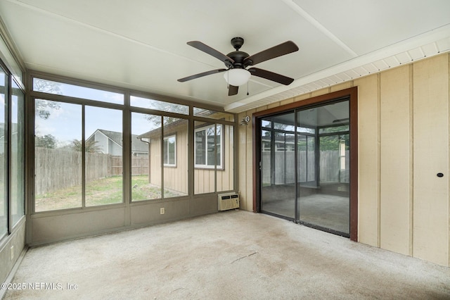 unfurnished sunroom featuring a wall mounted air conditioner and ceiling fan