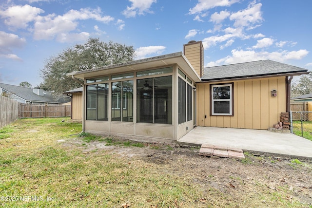 rear view of house featuring a patio, a sunroom, and a lawn