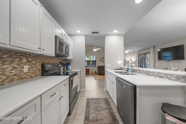 kitchen with white cabinetry, dishwasher, electric range oven, and sink