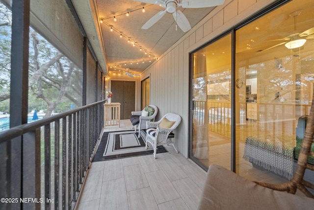 unfurnished sunroom with rail lighting and ceiling fan