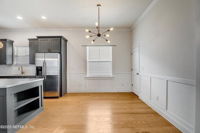 kitchen featuring ornamental molding, gray cabinetry, light hardwood / wood-style floors, and stainless steel fridge with ice dispenser