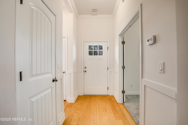 corridor featuring ornamental molding and light wood-type flooring