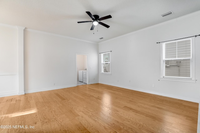 unfurnished room featuring crown molding, light hardwood / wood-style floors, independent washer and dryer, and ceiling fan