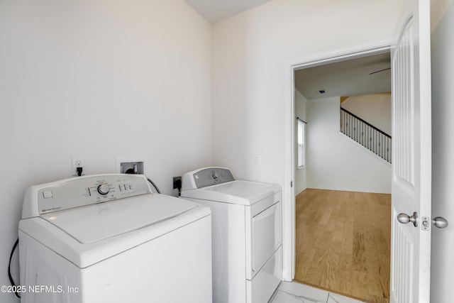 clothes washing area with separate washer and dryer and light hardwood / wood-style flooring