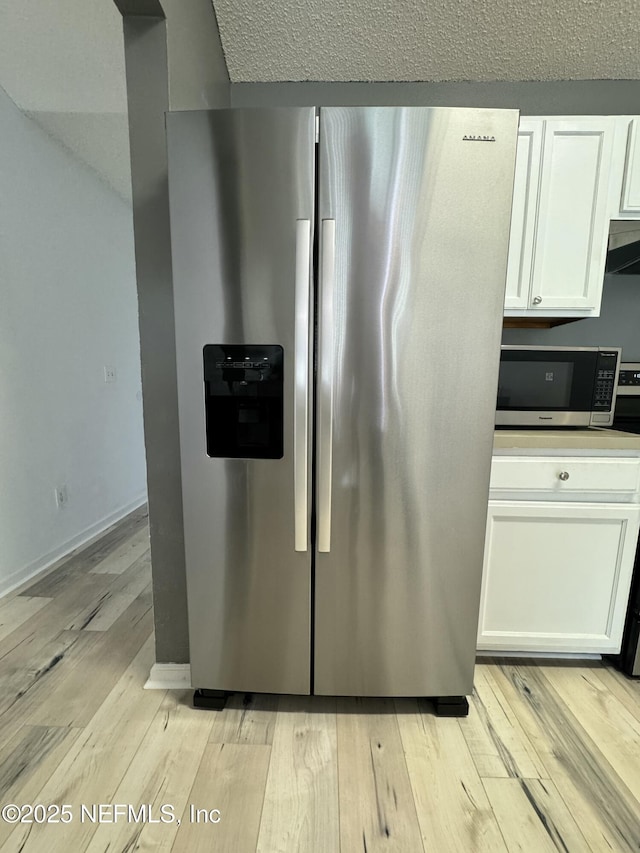 kitchen featuring white cabinetry, stainless steel appliances, and light wood-type flooring