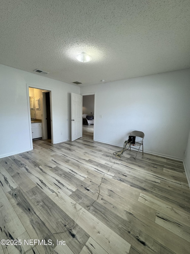 unfurnished bedroom featuring light hardwood / wood-style floors and a textured ceiling