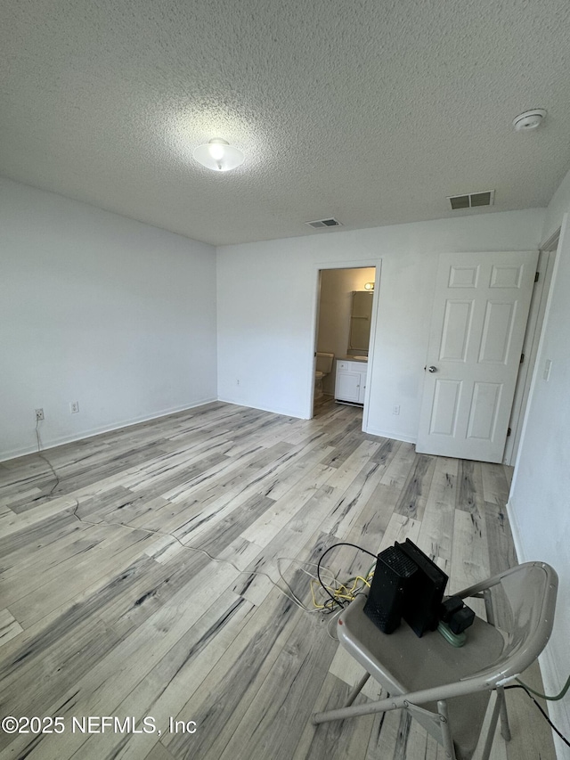 unfurnished bedroom featuring light hardwood / wood-style floors and a textured ceiling