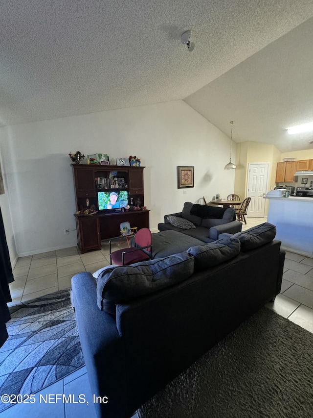 living room featuring vaulted ceiling, a textured ceiling, and light tile patterned floors