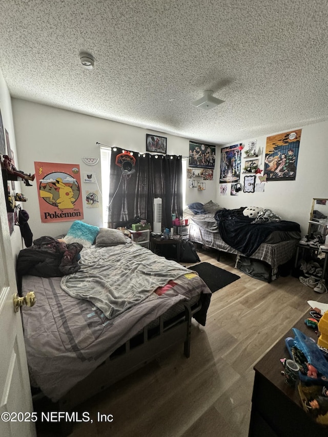 bedroom with wood-type flooring and a textured ceiling