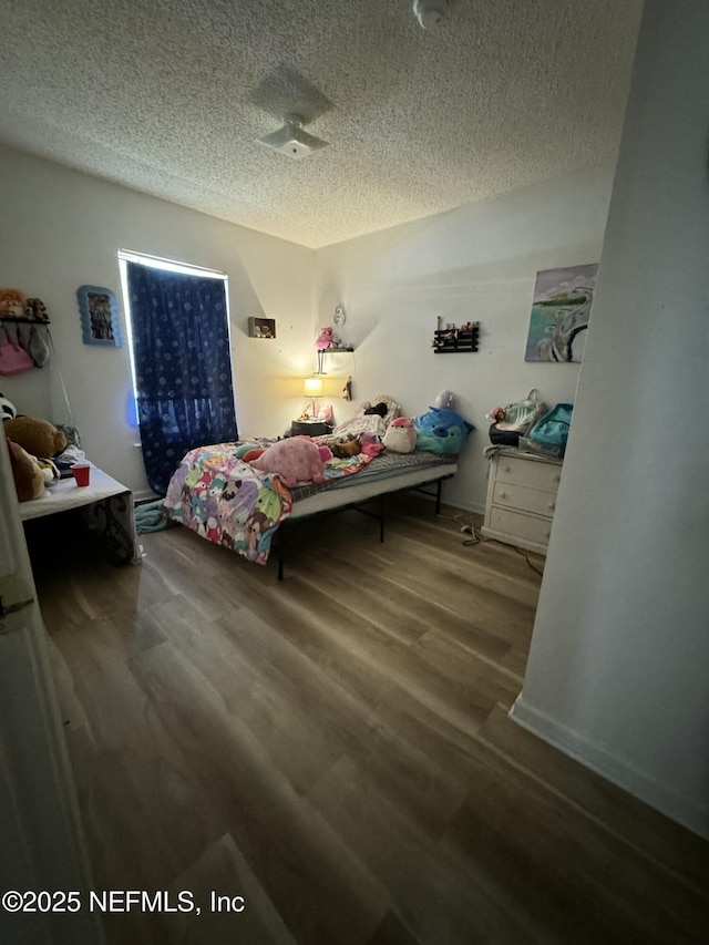 bedroom featuring wood-type flooring and a textured ceiling